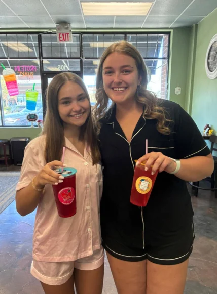 Two customers in matching pink pajamas holding shakes at Restore Nutrition in Plymouth, MN