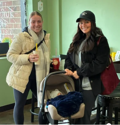 Two customers with a stroller enjoying drinks at Restore Nutrition