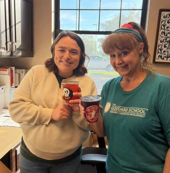 Two customers holding seasonal shakes at Restore Nutrition