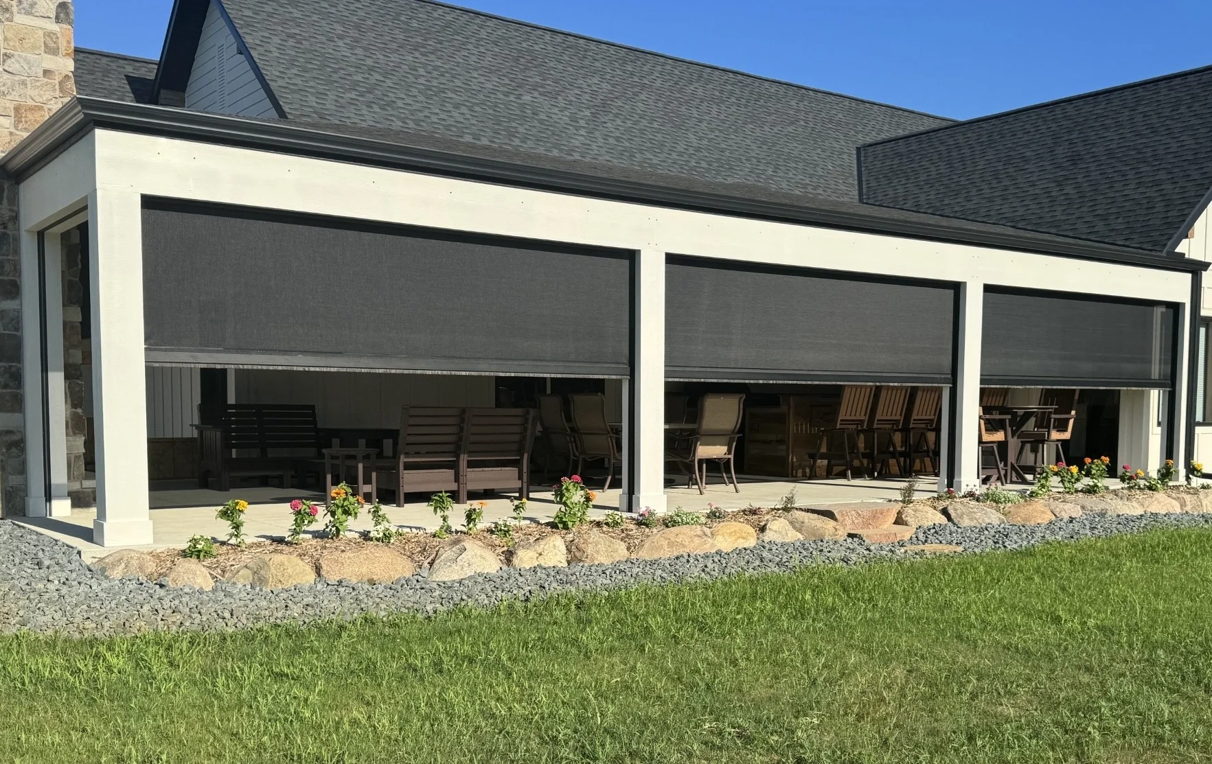 A motorized Sentry retractable patio screen enclosing a covered outdoor living area at a Minnesota home