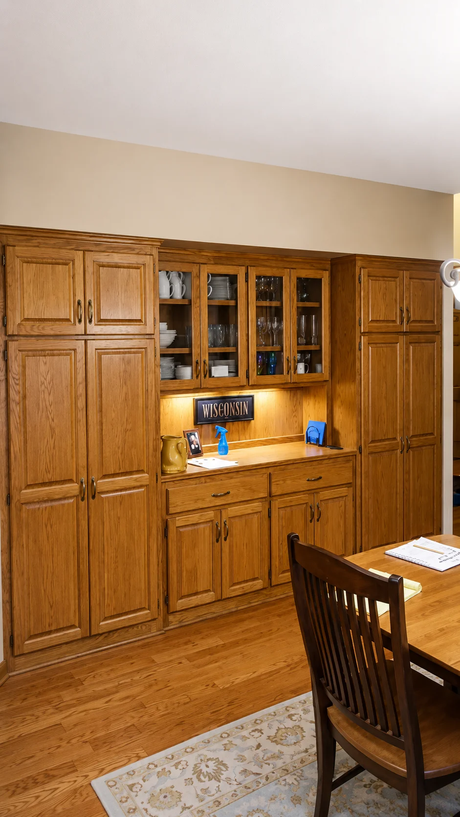 Warm neutral wall color above stained wood cabinetry in a finished kitchen and dining area.