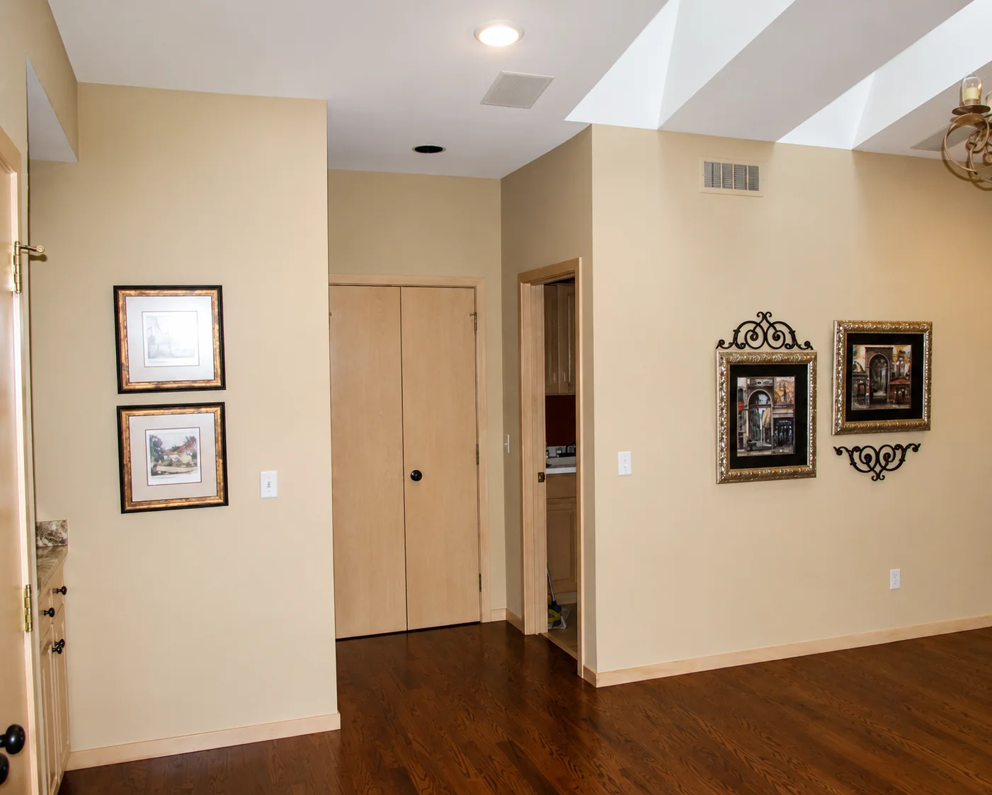 Freshly painted beige interior walls with clean ceiling lines and wood floors in a bright room.