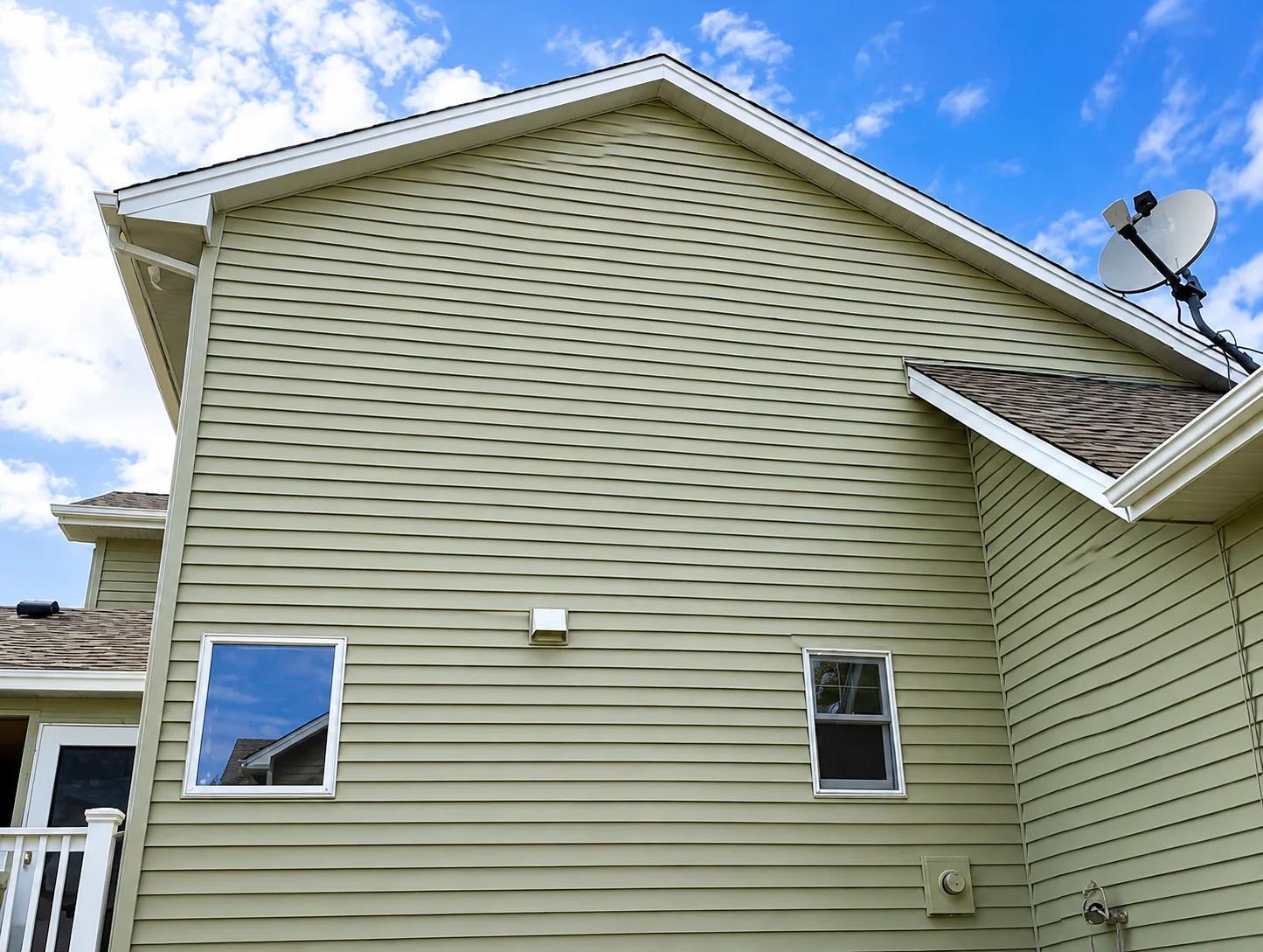 Freshly painted exterior siding on a home under bright blue skies.