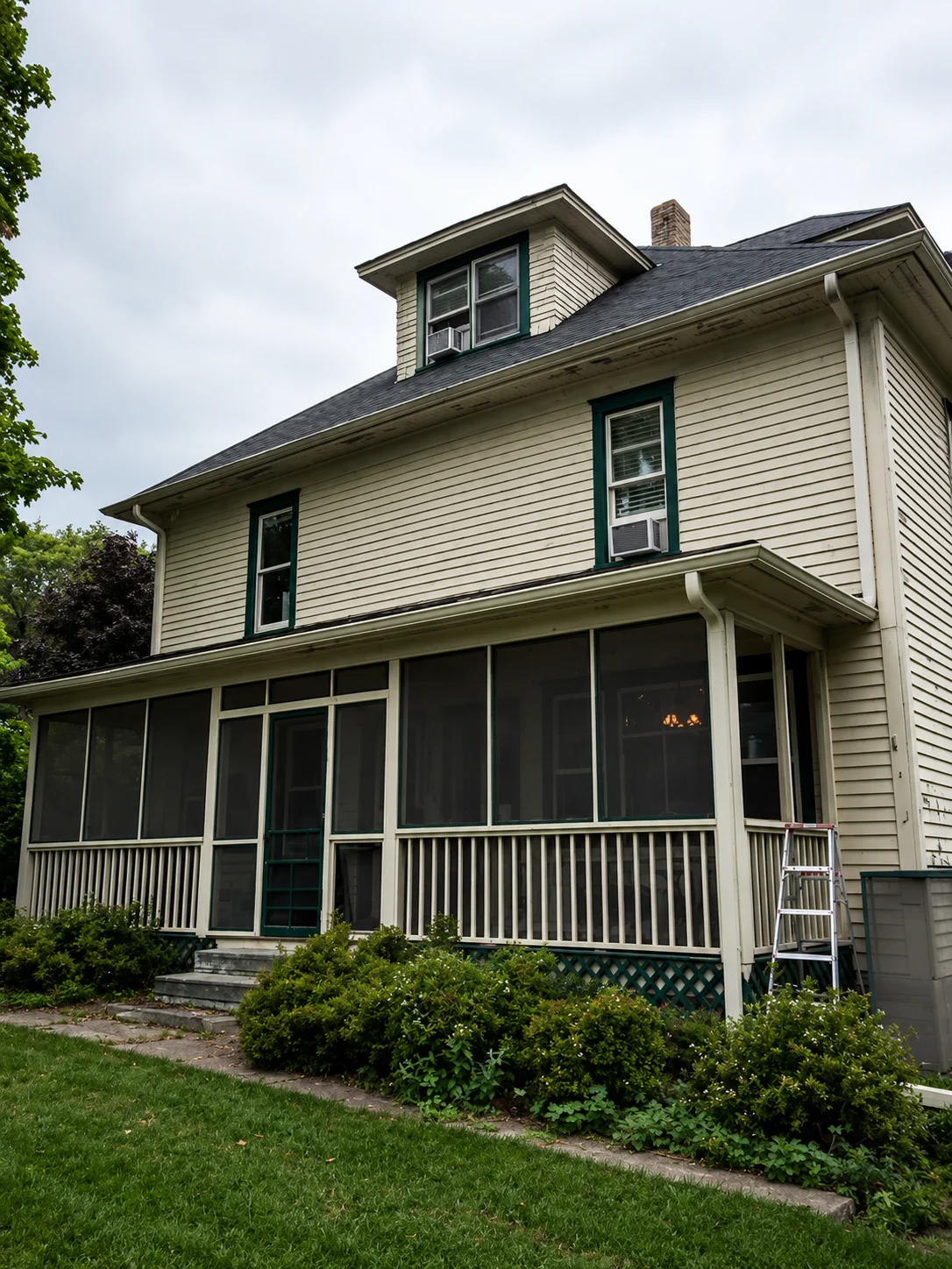 Before shot: original cream siding with dark green trim, prior to Webster's Quality Painting exterior repaint.
