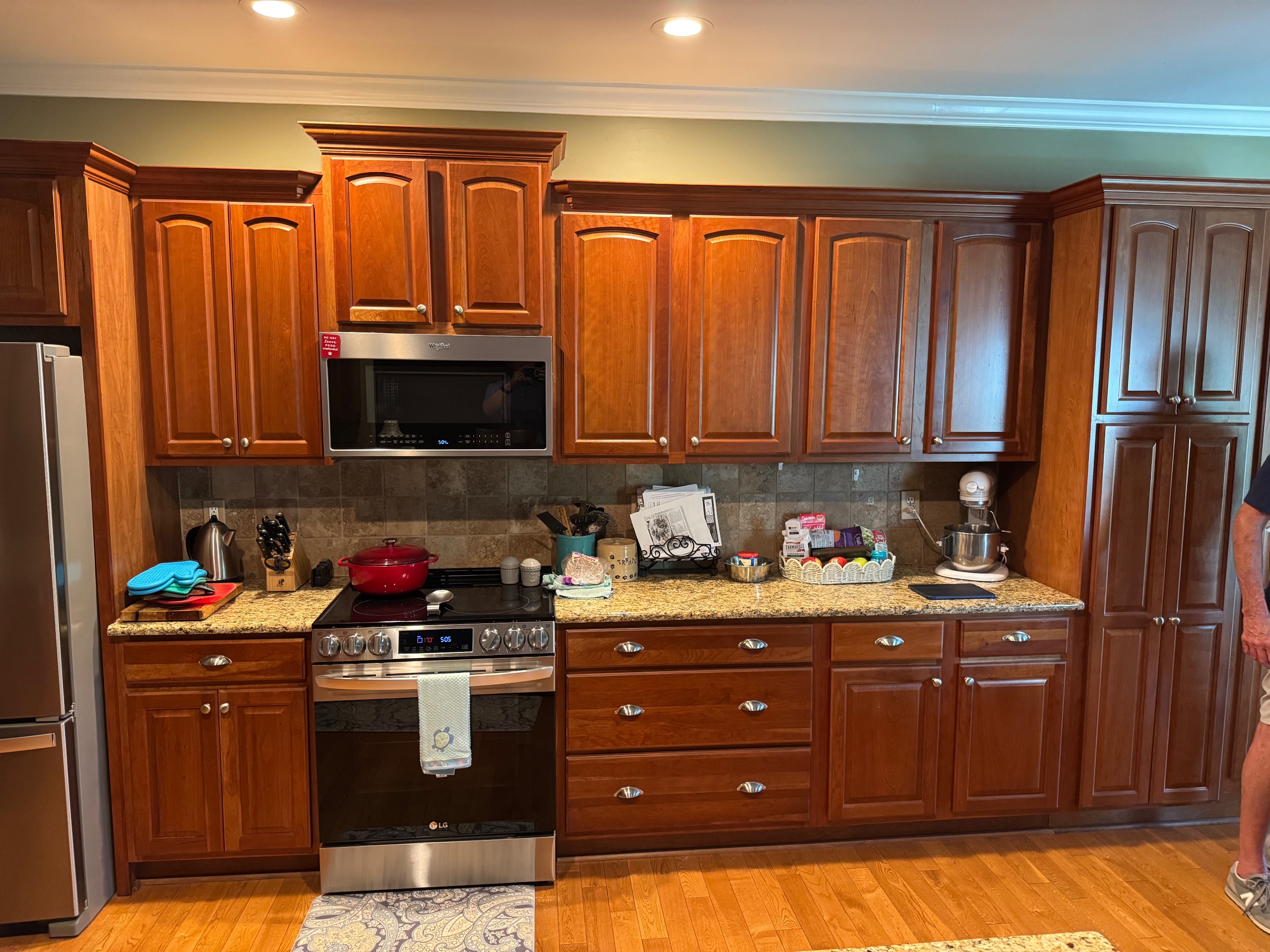 Before photo of a dated kitchen with cherry cabinets and tile backsplash in Fairfield Harbor, New Bern, prior to remodeling.