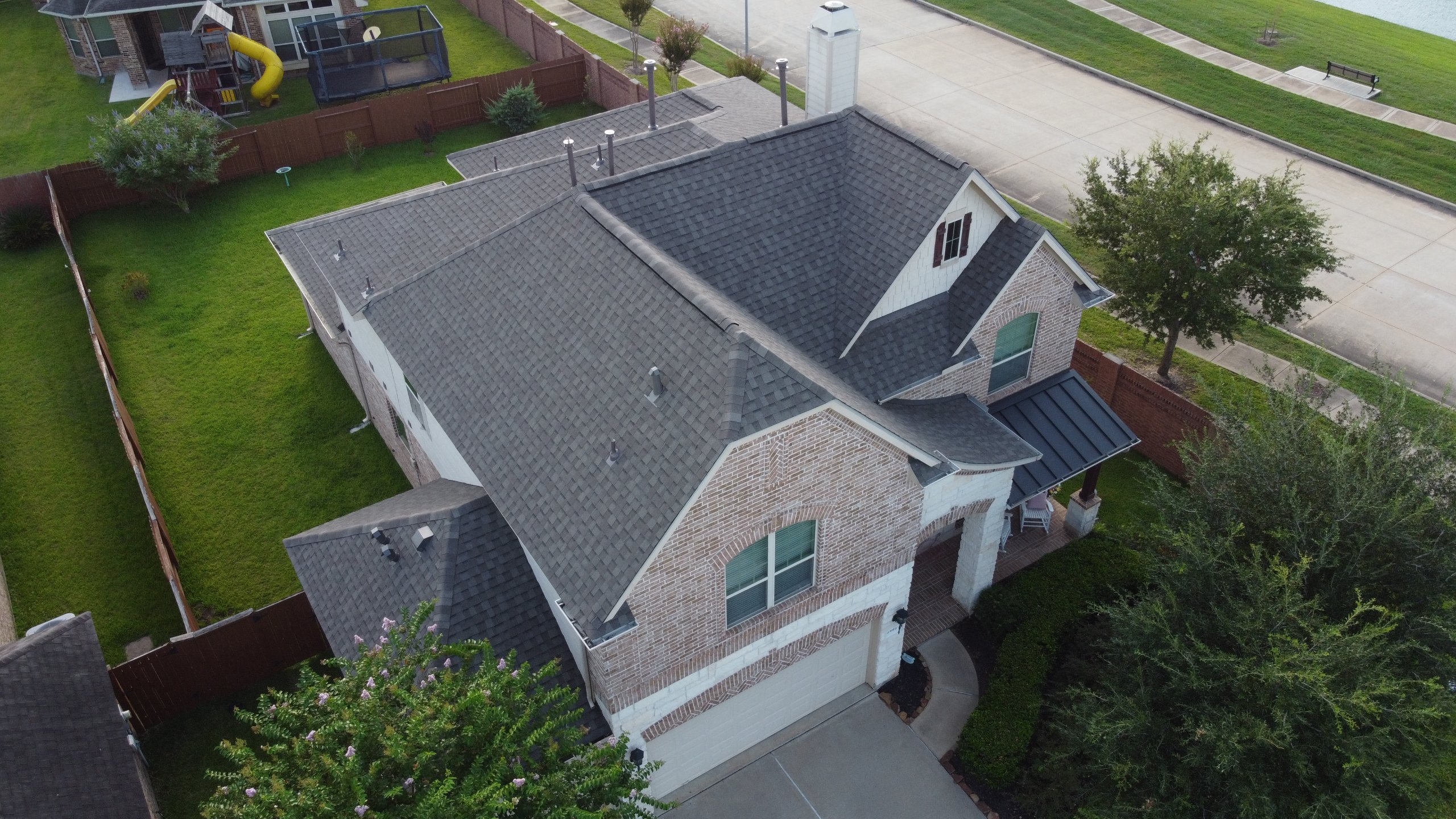 Aerial view of a completed roof replacement in Sugar Land, TX, installed with a 160 mph wind-rated warranty.