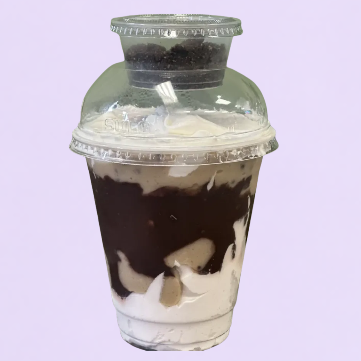 Oreo Cheesecake parfait layered in a cup with crushed cookies and cream