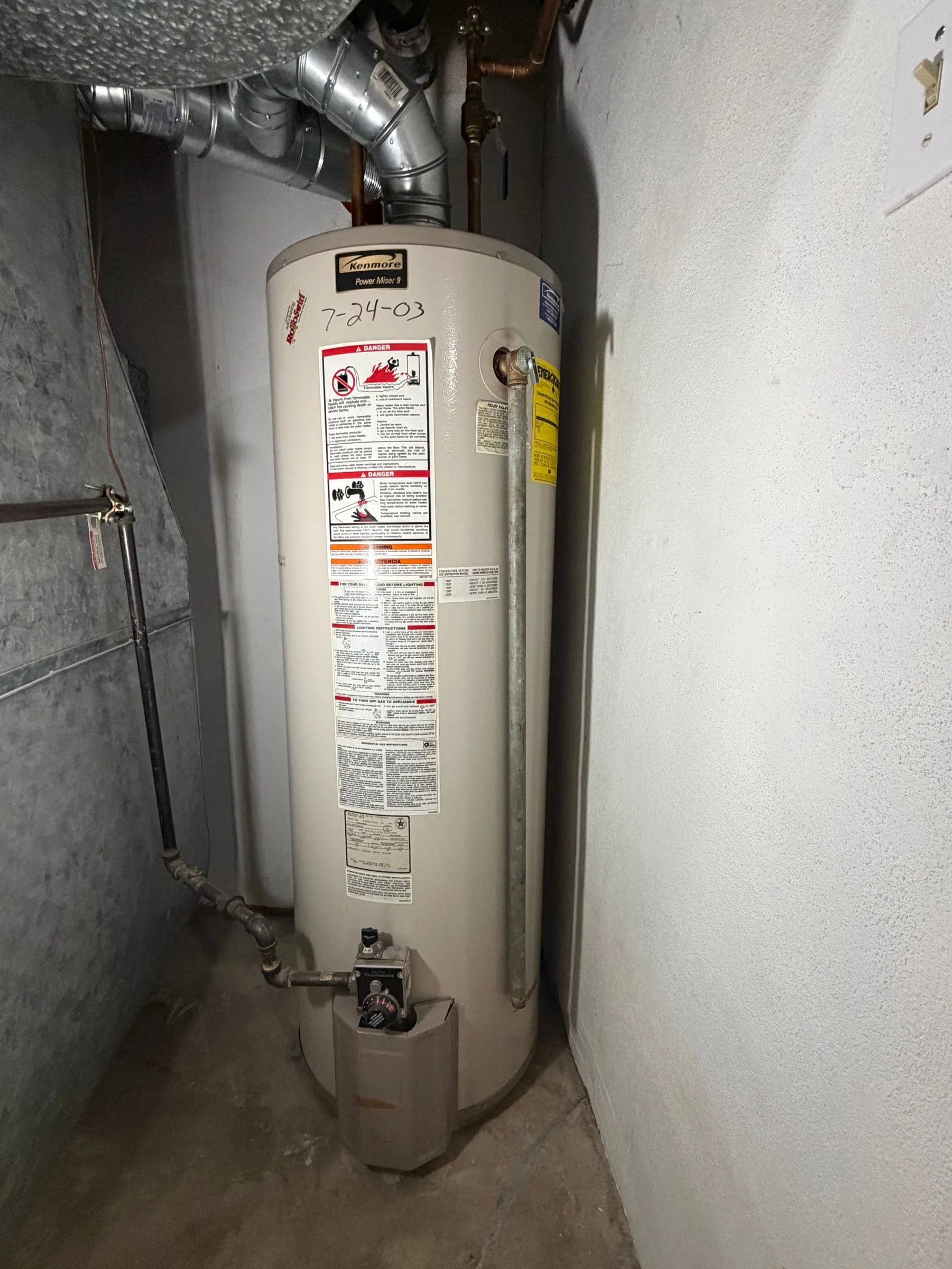 Old worn water heater before replacement by Summit Peak Plumbing