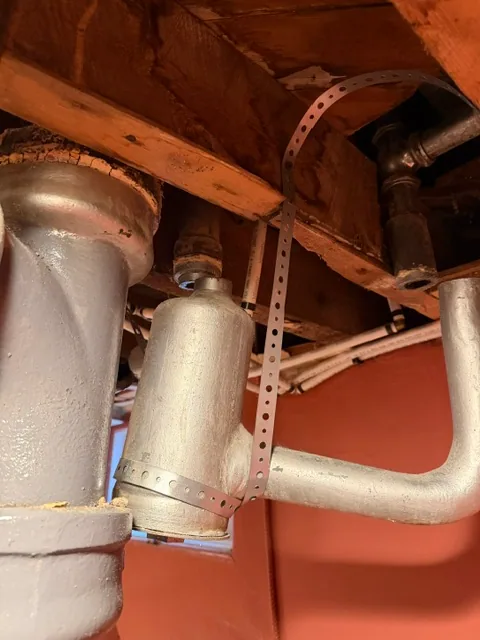 Old drum trap being cut out from a shower and bathtub drain line