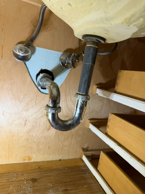 Oxidized chrome plated P-trap under bathroom sink needing replacement