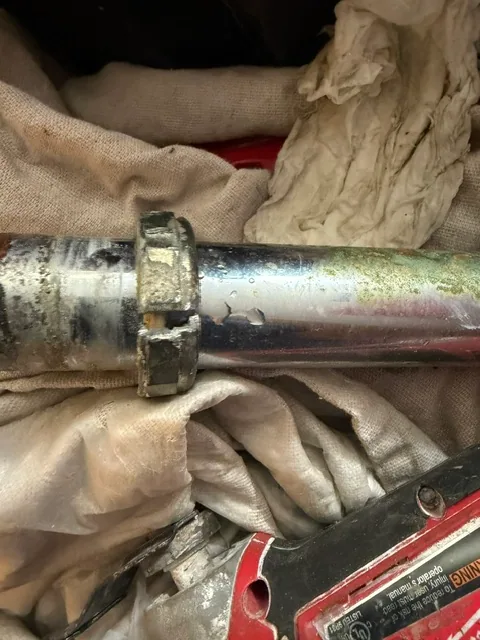 Seized brass slip nut on trap adapter being cut with oscillating tool