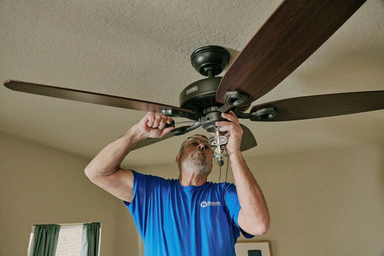 Craftsman installing a ceiling fan