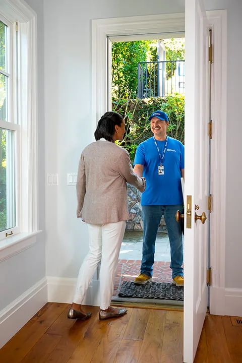 Craftsman greeting a homeowner at her front door