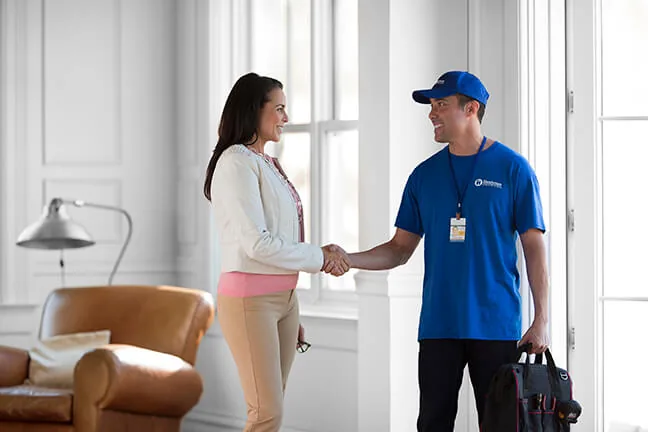Craftsman shaking hands with a homeowner in a living room