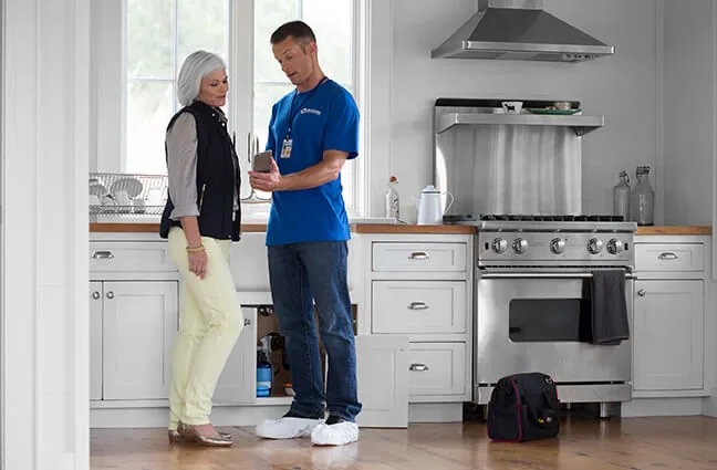 Craftsman going over a work order with a homeowner in her kitchen