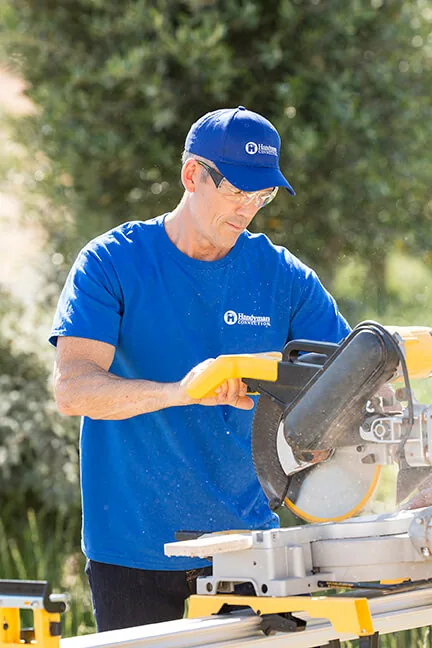 Craftsman in safety glasses at a miter saw
