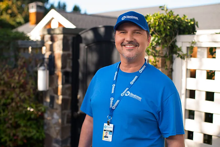 Smiling Handyman Connection craftsman outside a home