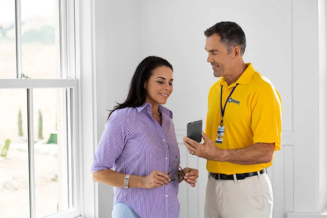 Handyman Connection team member reviewing an estimate with a homeowner on a tablet