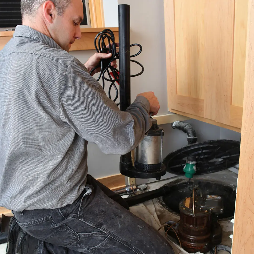 Sump pump being serviced in a basement pit