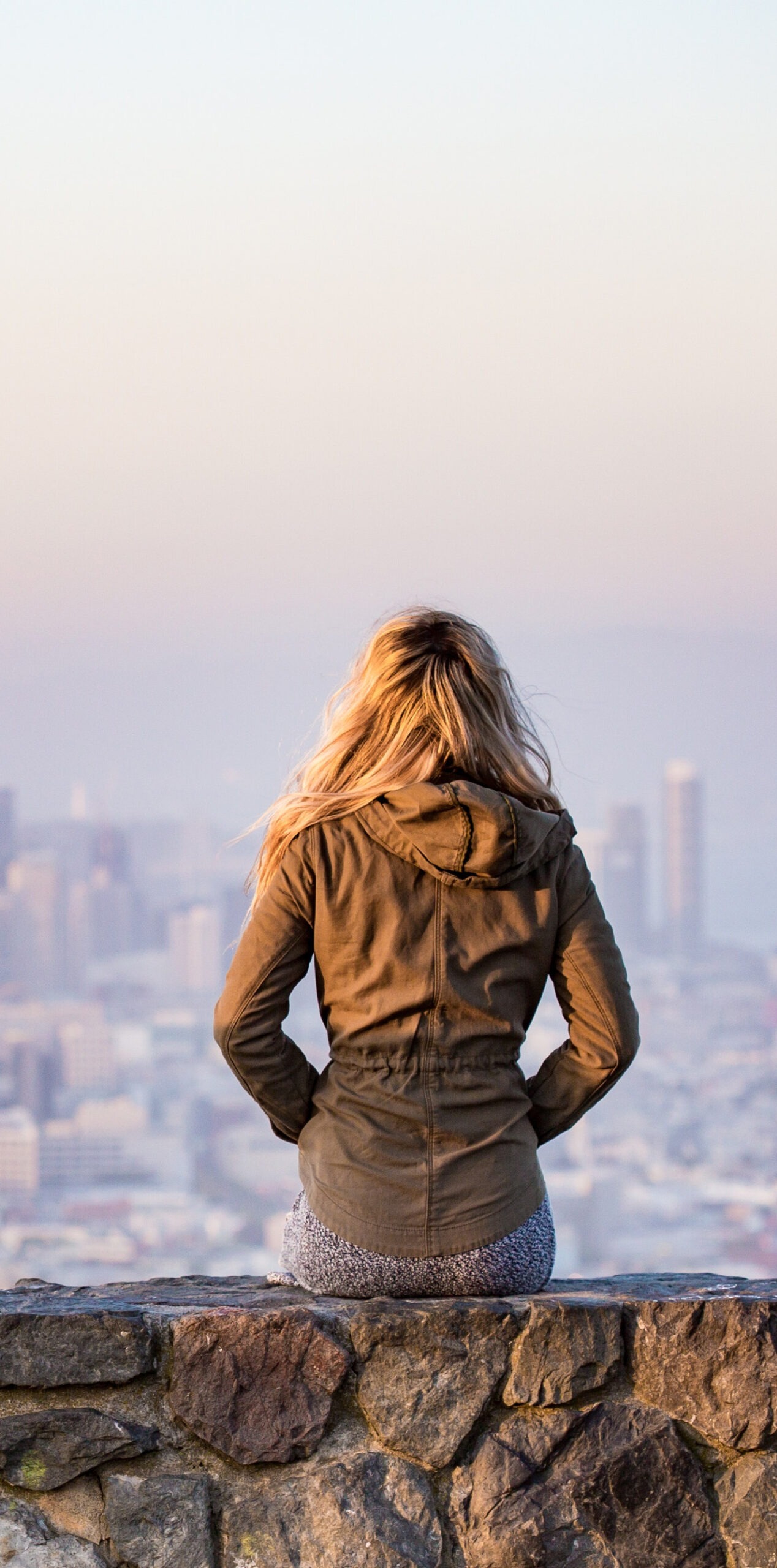 Woman standing with back to camera overlooking city skyline - conflict resolution for couples