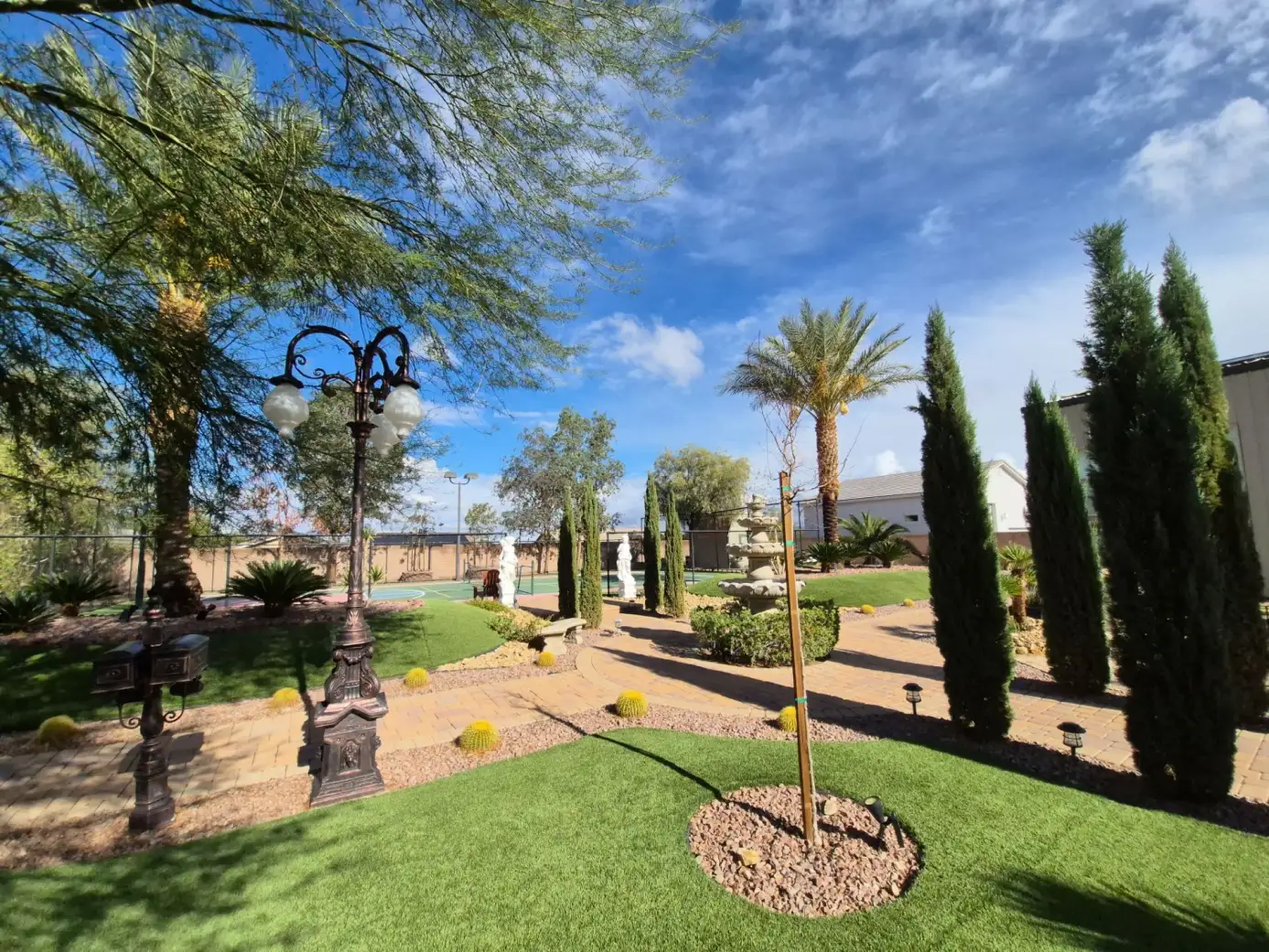 Landscaped residential garden featuring lawn care, ornamental plantings, hardscaping, and outdoor lighting in a desert-style Arizona setting.