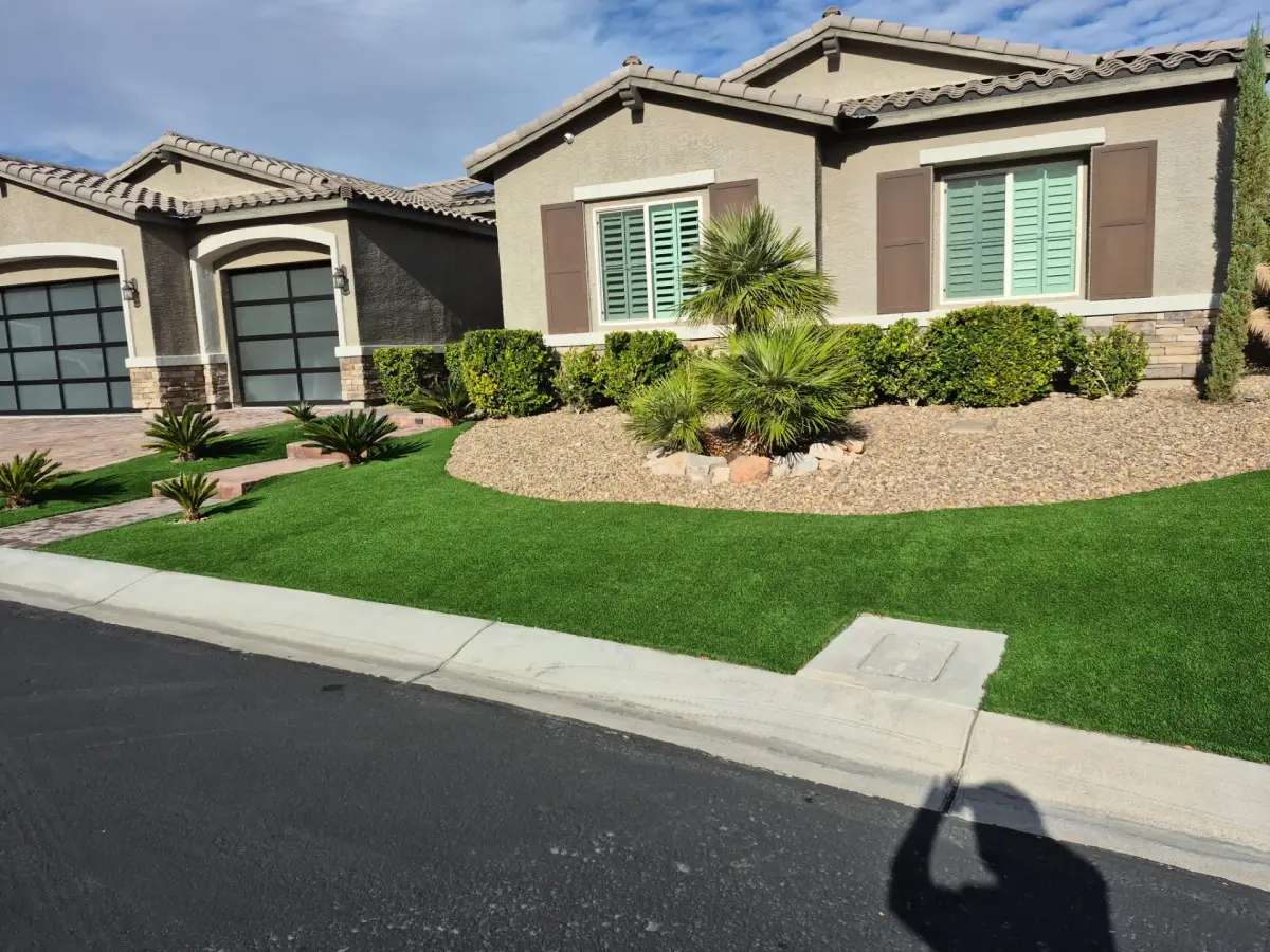 Lawn installation and desert landscaping with drought-tolerant plants and hardscaping in a residential front yard.