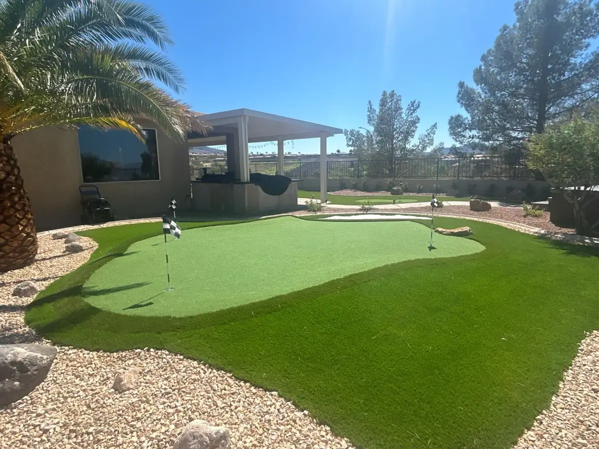 Artificial turf installation with putting green features in a residential backyard landscape.