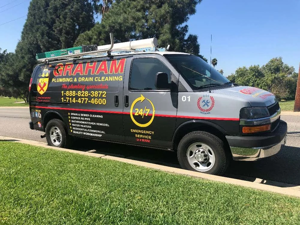 A branded service van for plumbing and drain cleaning parked on a residential street.