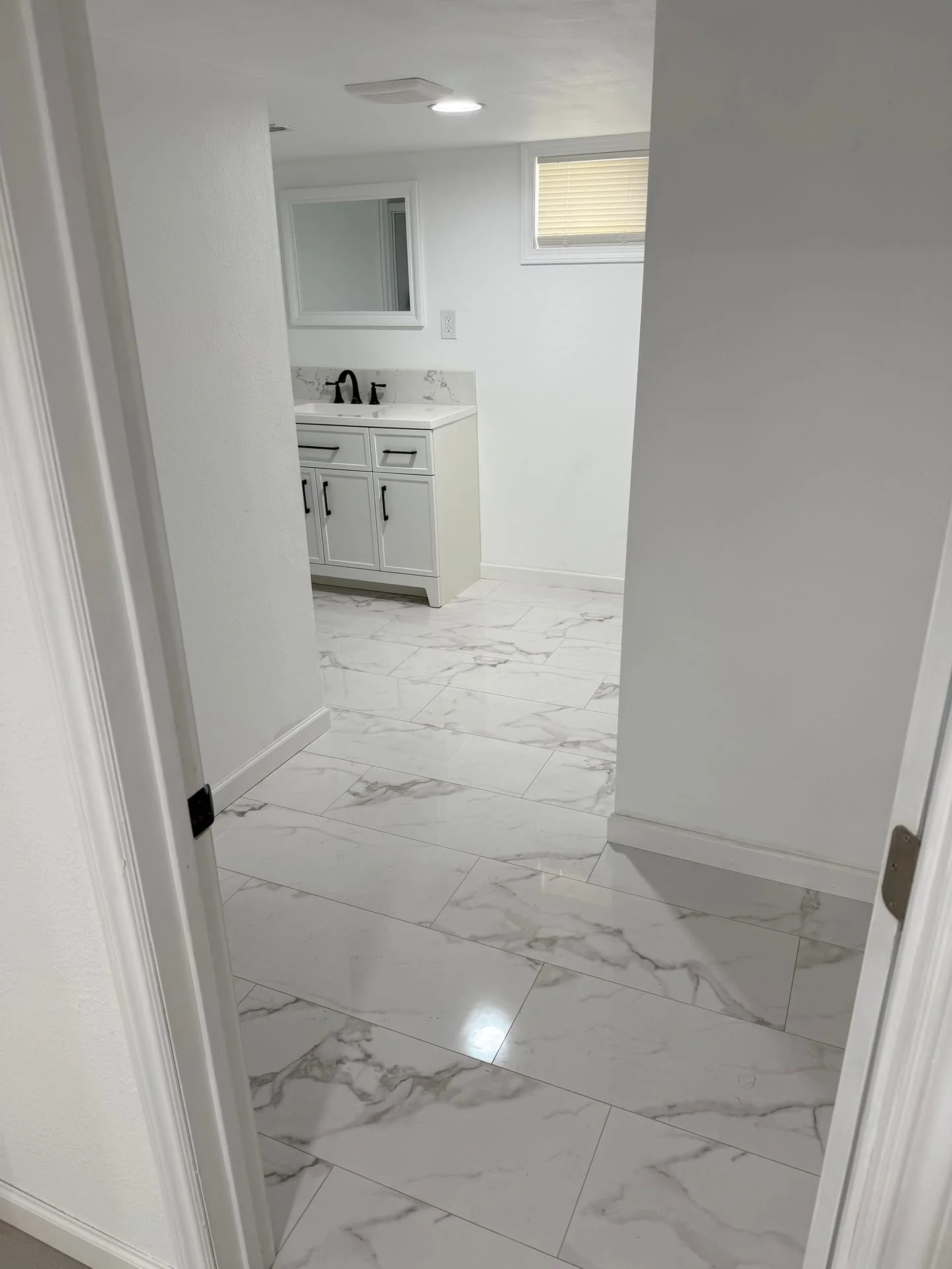 Bathroom vanity and tile flooring installation in a newly renovated bathroom space.