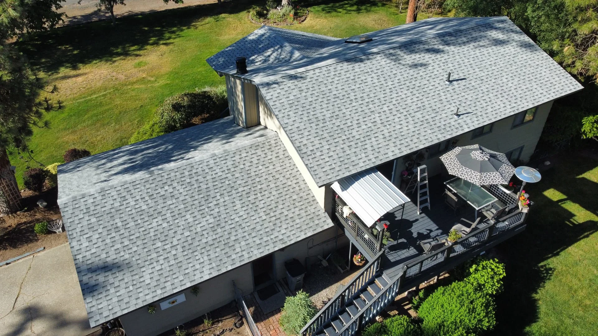Newly installed asphalt shingle roof on a residential home with completed exterior work visible from an aerial perspective.