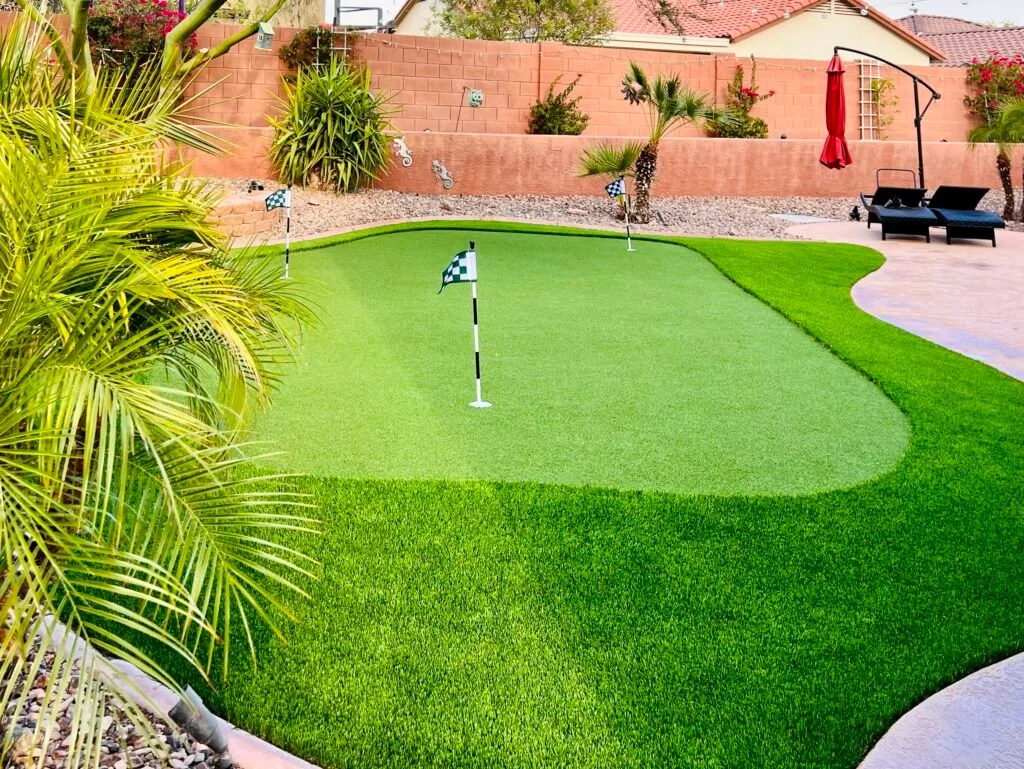 Synthetic putting green installed in a Phoenix backyard with desert landscaping and patio surrounding it