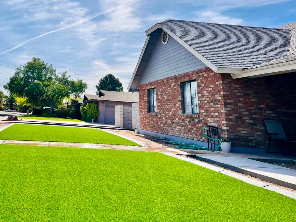 A freshly installed sod lawn in front of a brick residential home with attached garage.