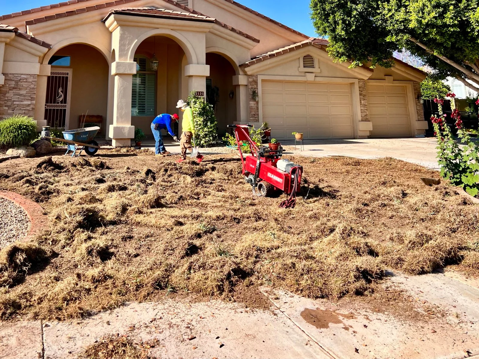 Landscape soil and mulch installation in a residential front yard during active landscaping work.