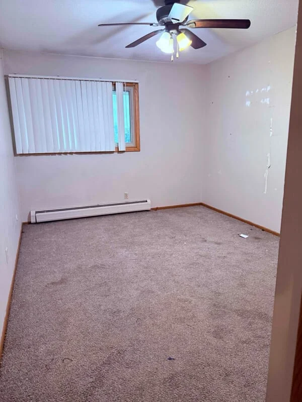 An empty residential bedroom shown as a finished result after junk removal work.