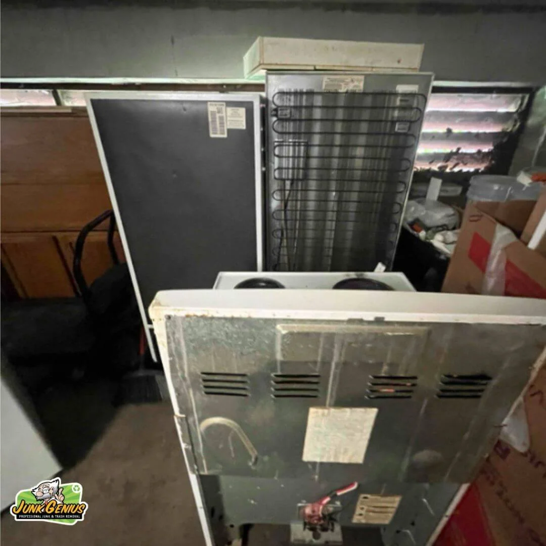 Appliance junk removal showing discarded refrigerators and other large household items in a storage or collection area.
