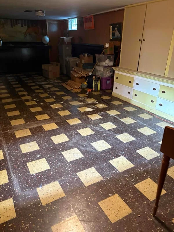 A basement or storage room cluttered with boxes, bags, and miscellaneous items awaiting junk removal in a residential space.