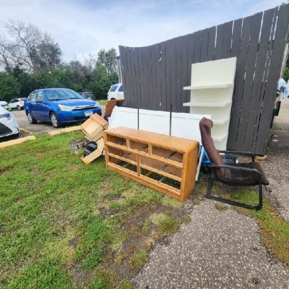 Junk removal service in progress showing furniture and household items staged for pickup in a residential driveway.