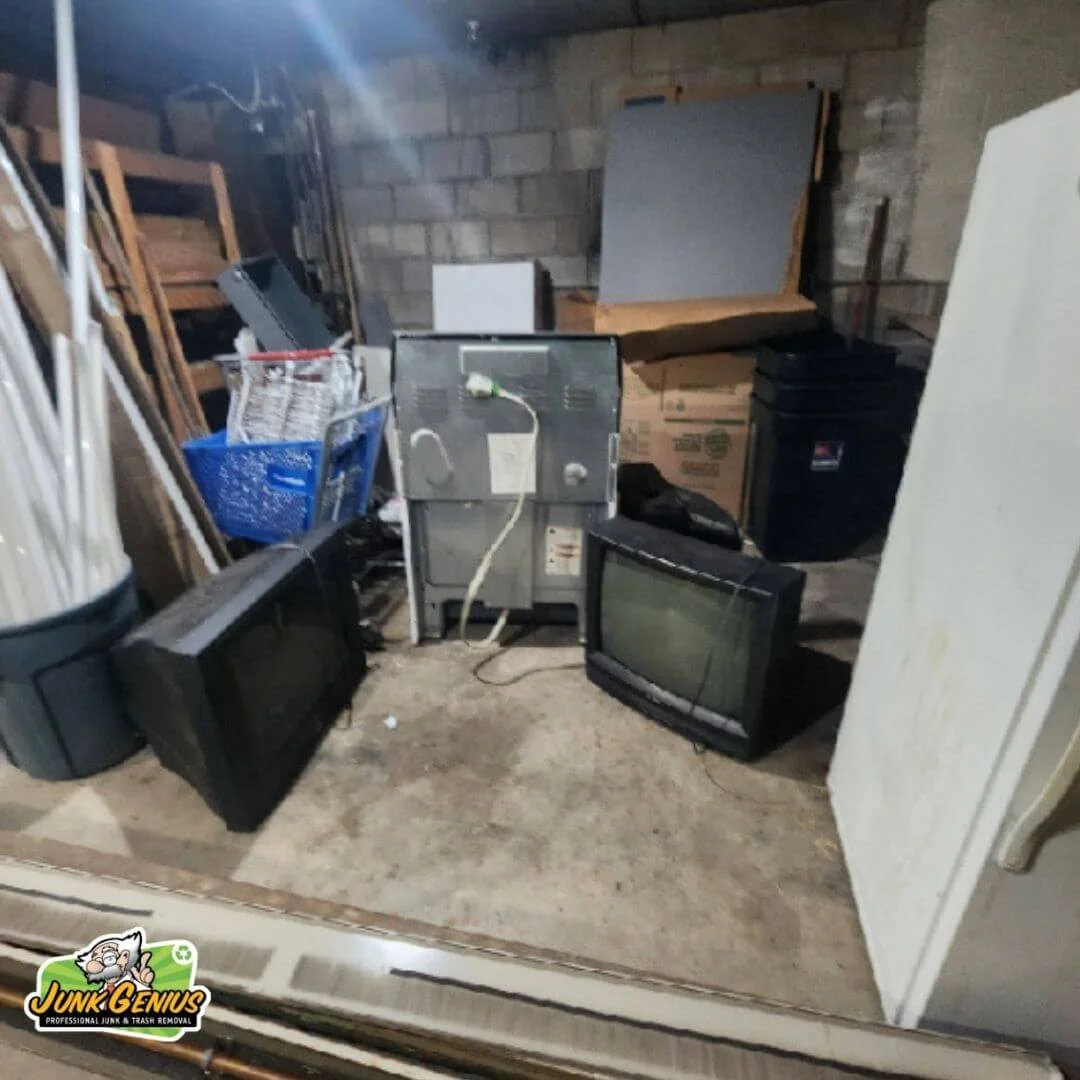 Junk removal service in progress showing a basement or storage space being cleared of old electronics, furniture, and miscellaneous items.