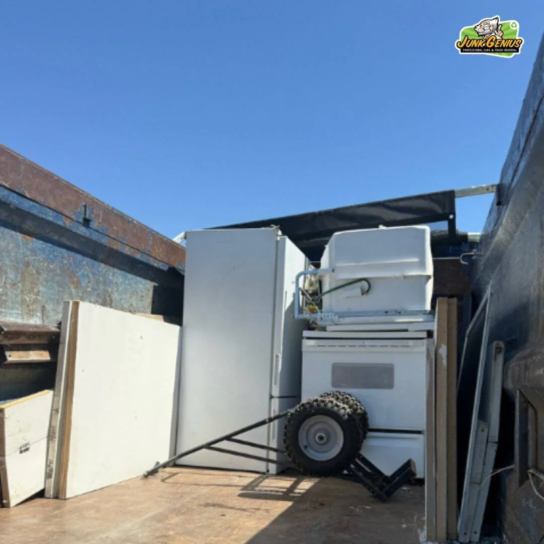 Junk removal service in progress, showing appliances and household items being loaded onto a trailer for disposal.