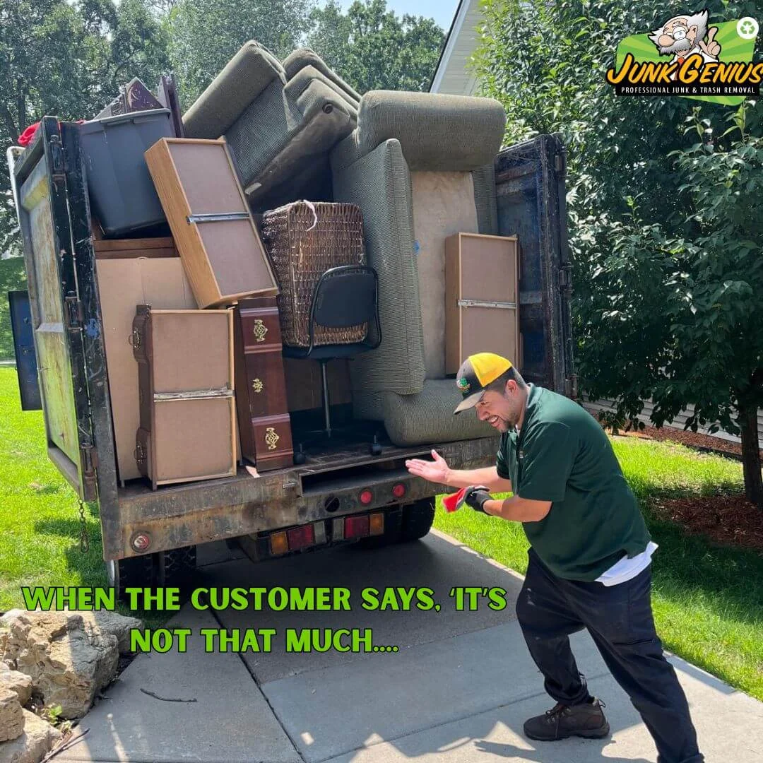 Junk removal service in progress with a fully loaded truck containing furniture, appliances, and household items ready for hauling away from a residential driveway.