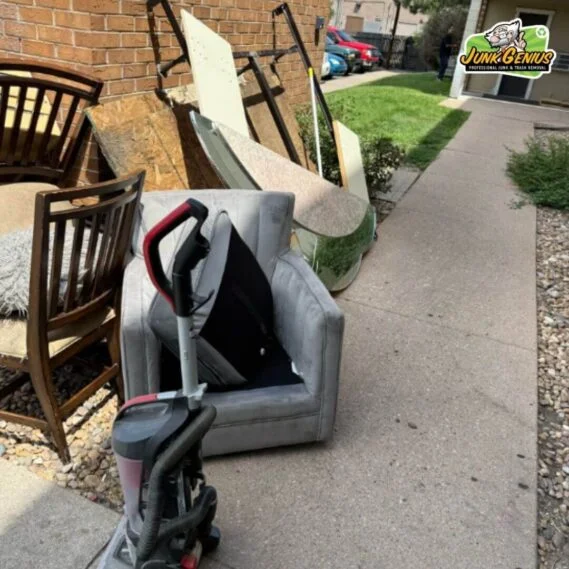 Junk removal service showing collected household items and furniture awaiting disposal in a residential driveway.