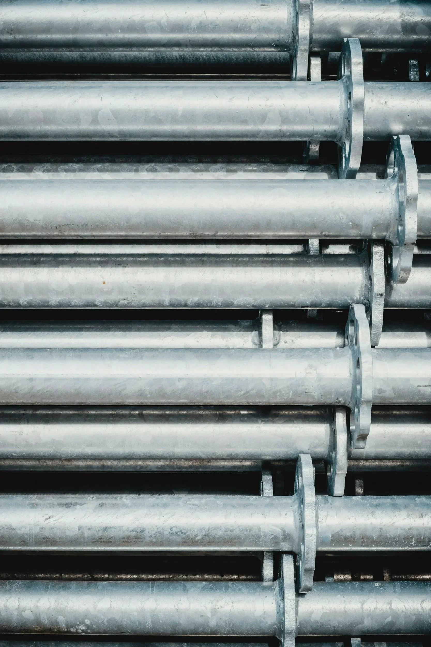 Industrial metal pipes bundled together with metal straps in a storage or inventory setting.