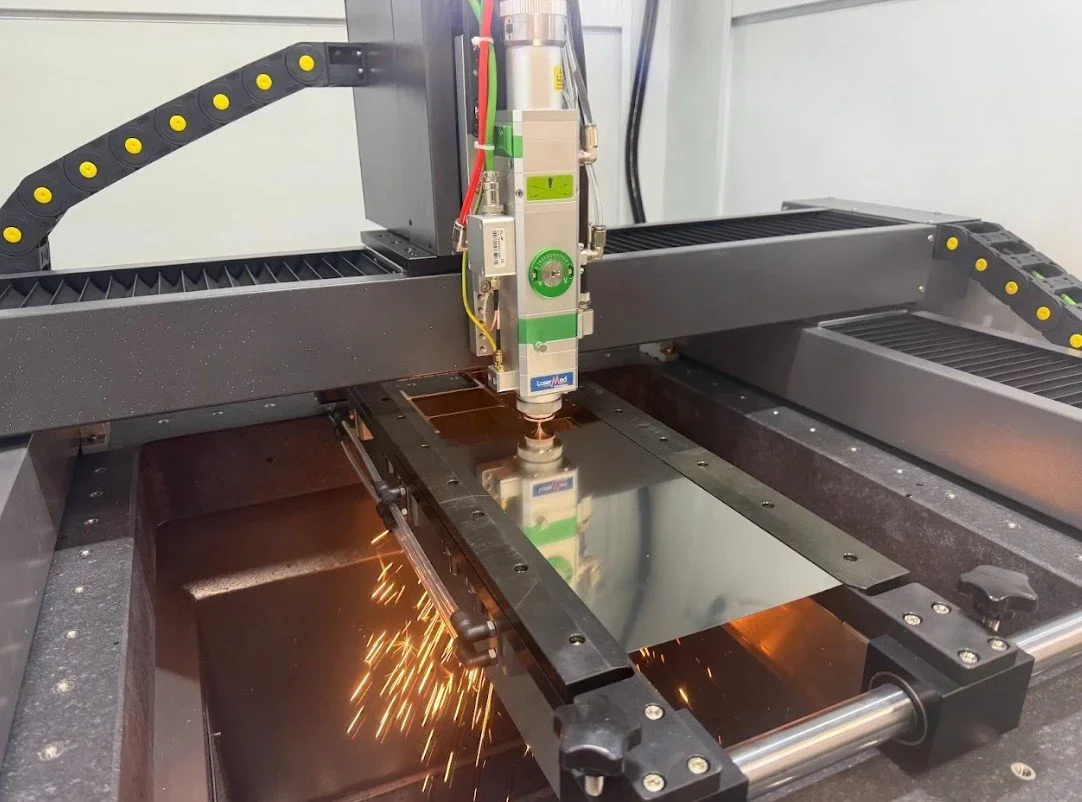 A laser cutting machine actively cutting material in an industrial workshop setting.