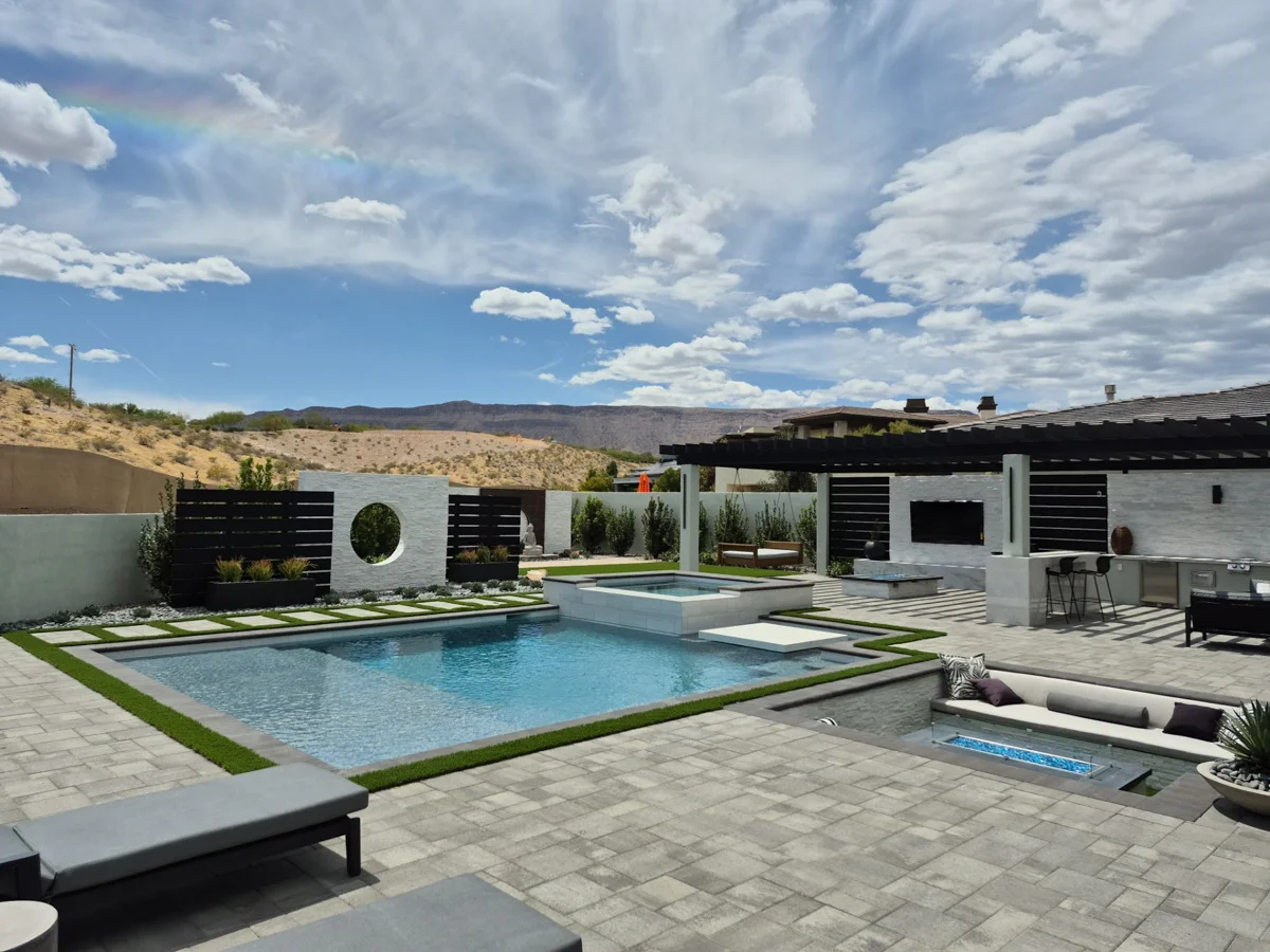 Hardscape patio and pool installation in a modern residential backyard with desert mountain views.