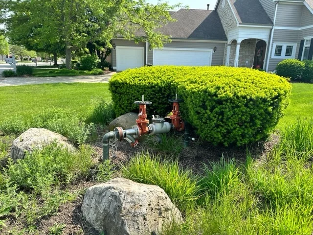 Water shutoff valves and underground plumbing infrastructure installed in a residential front yard landscape.