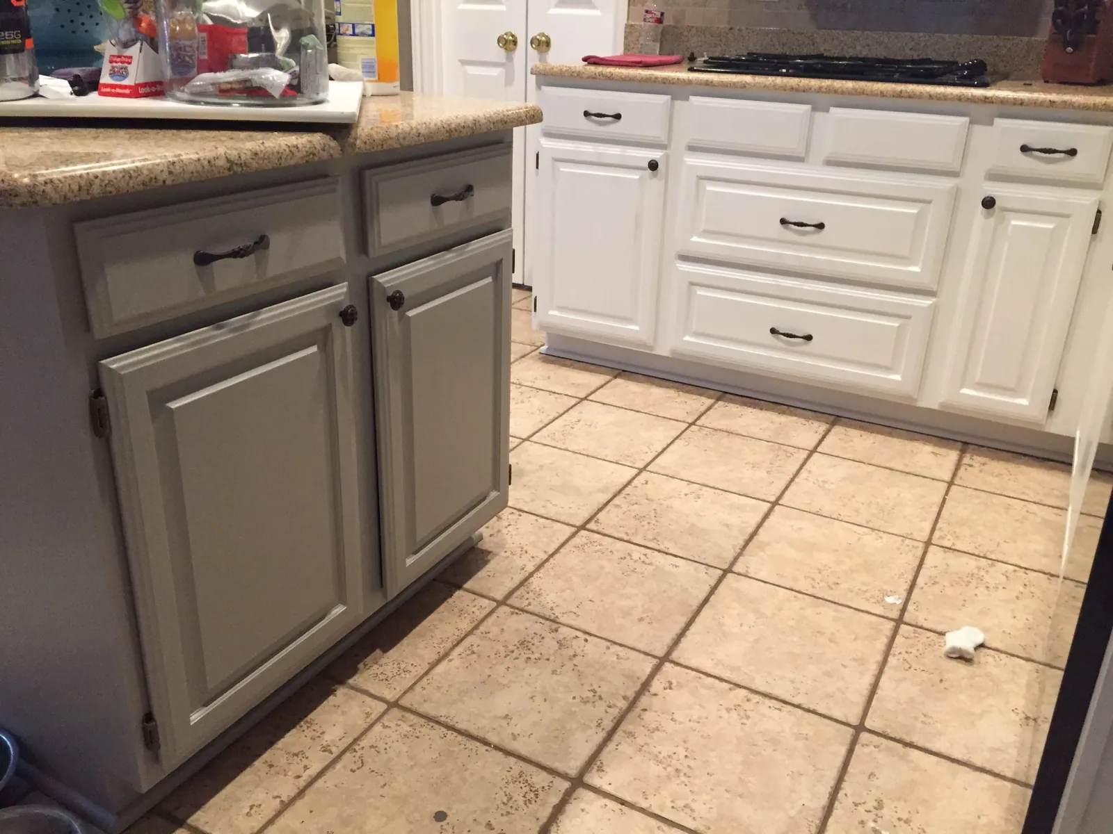 White painted lower cabinets and a gray island