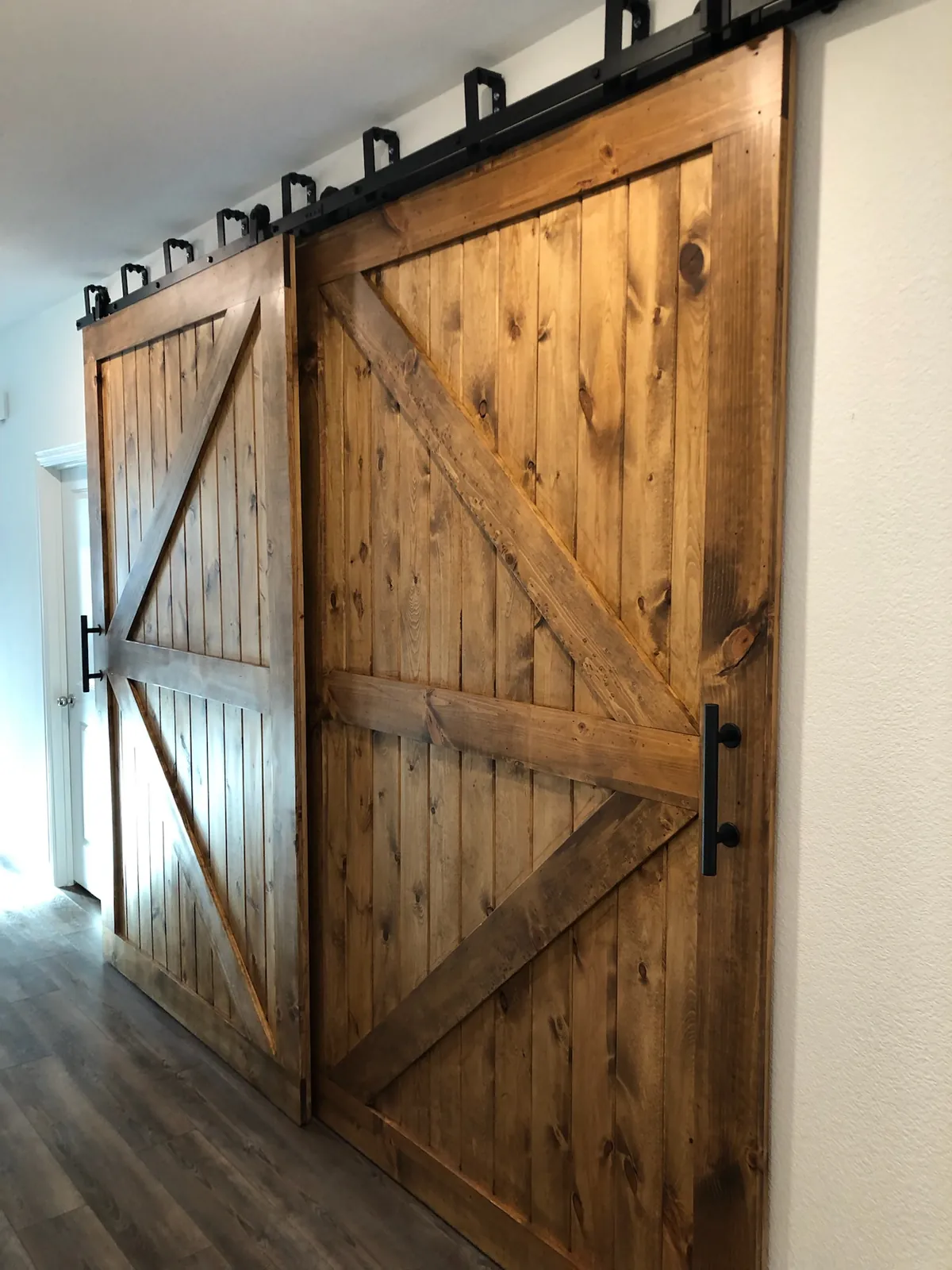 Stained cedar barn door hung on black hardware