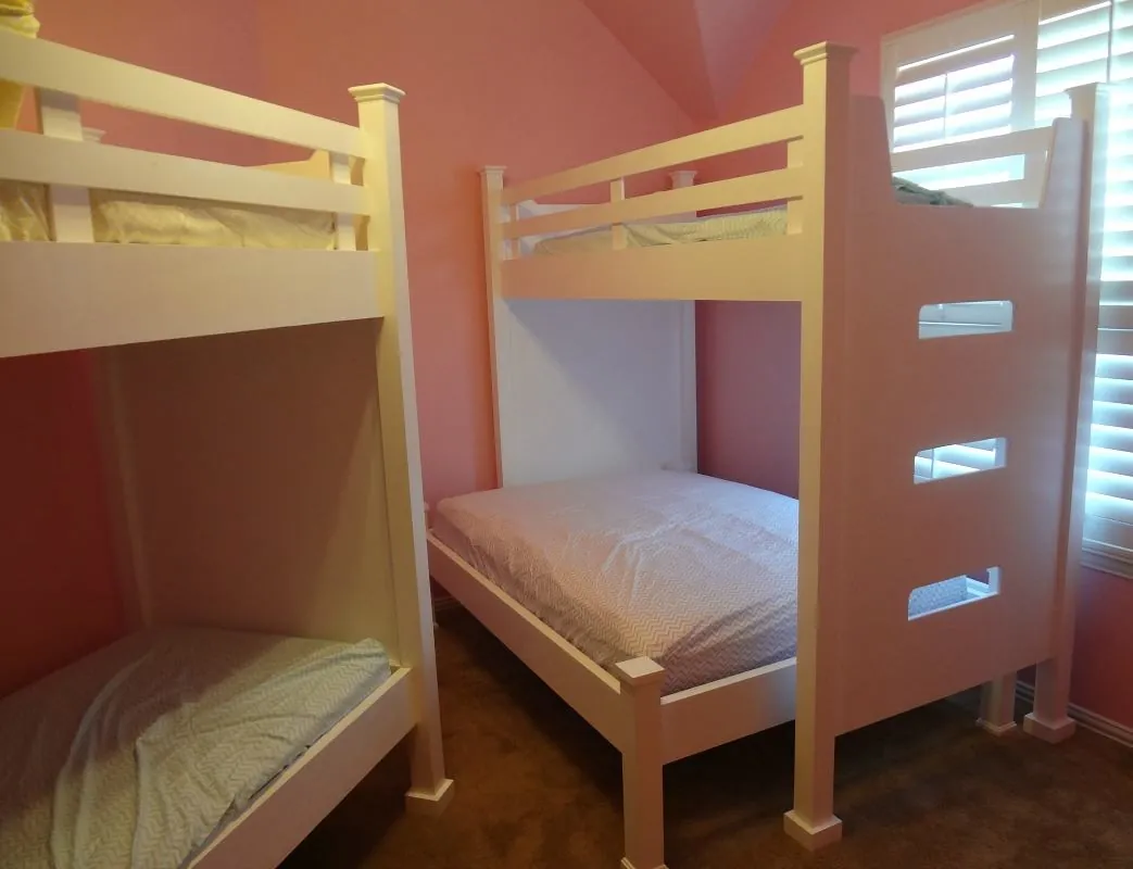 Custom white bunk beds with a ladder