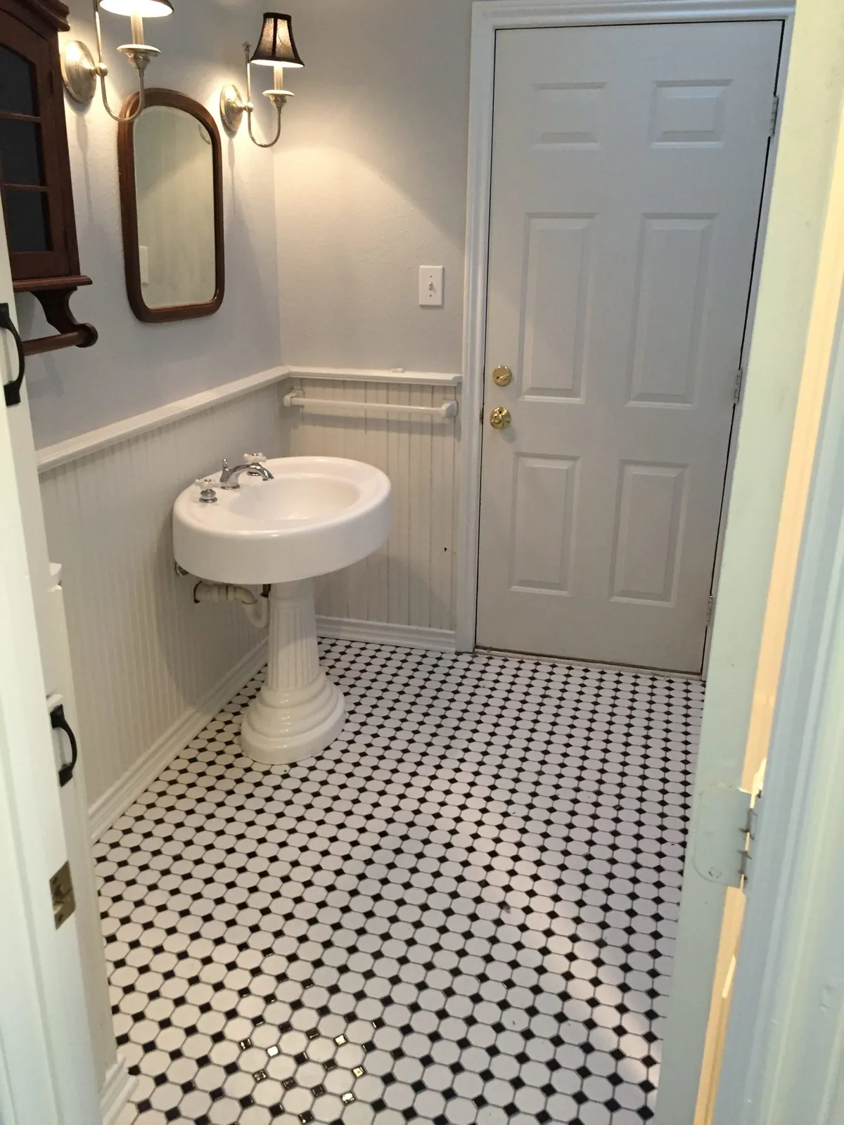Bathroom with black and white hex tile and a pedestal sink