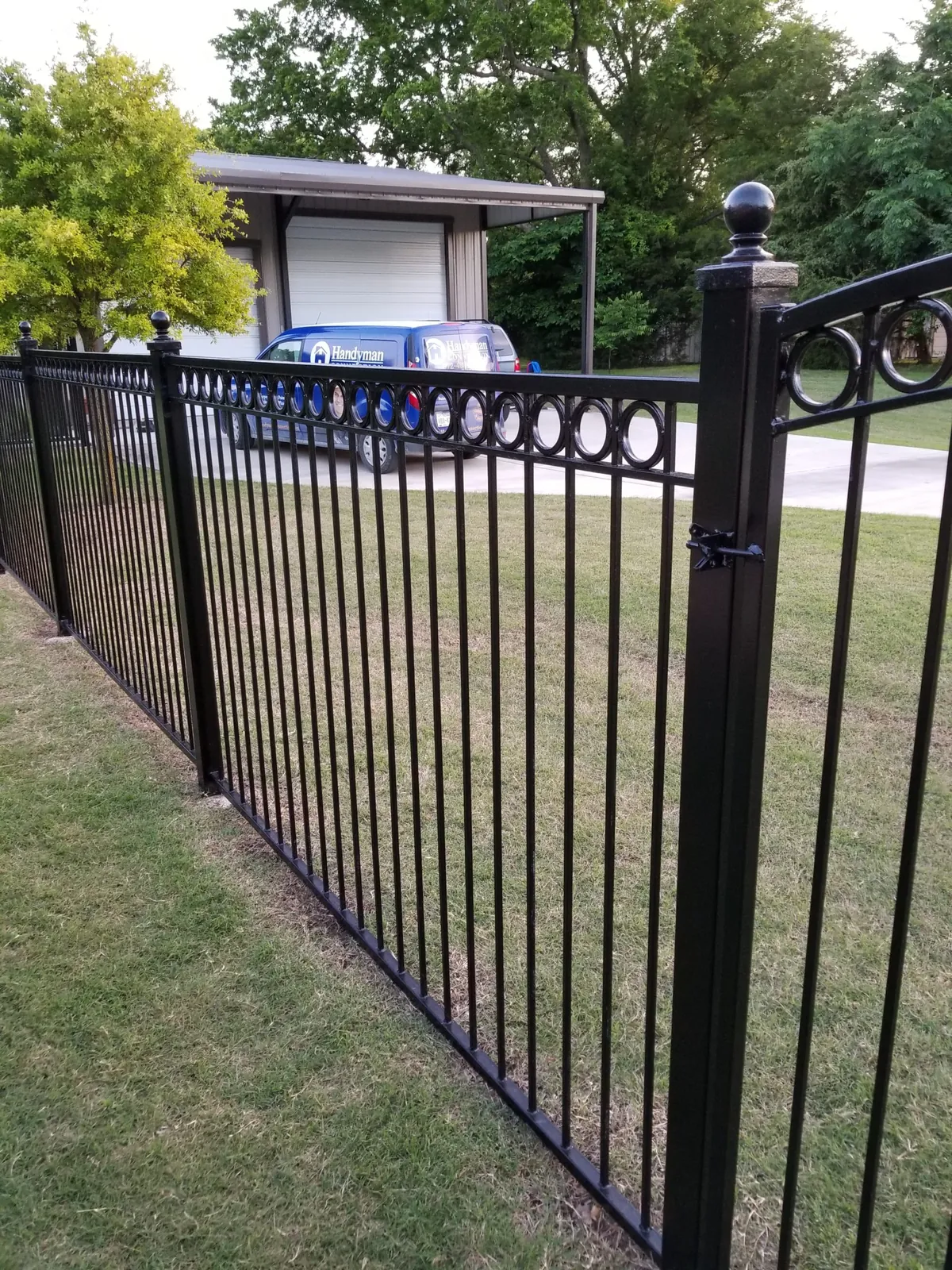 Black iron fence and gate along a yard